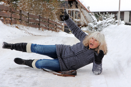 Unfallgefahr im Winter - Eine Frau ist auf einer schneeglatten Straße ausgerutscht
