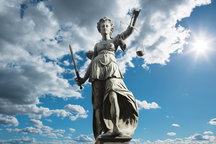 Justitia Symbol für Gerechtigkeit vor Himmel mit Wolken