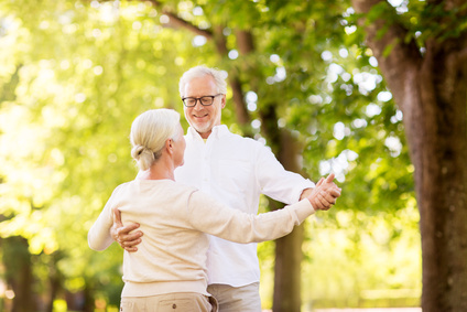 happy senior couple dancing at summer park