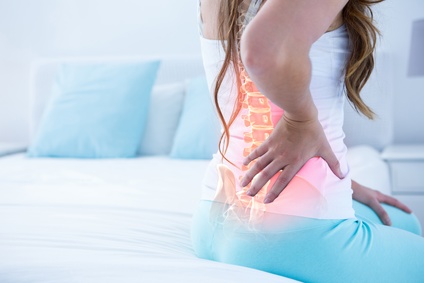 Digital composite of highlighted spine of woman with back pain